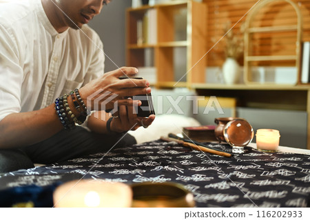 Selective focus on hands shuffling tarot cards during reading session. Forecasting and divination concept 116202933