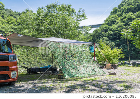 [Auto camping site: Tarp set up in the woods, hanging net] 116206085