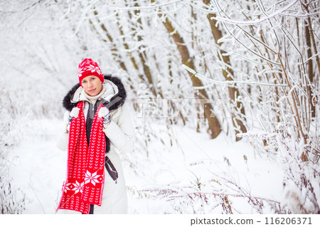 Portrait of happy young woman in winter forest 116206371