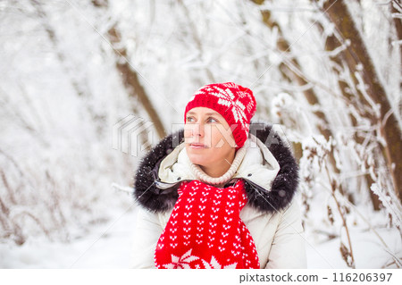 Portrait of happy young woman in winter forest 116206397