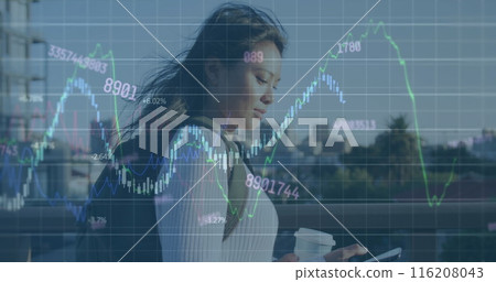 Image of graphs and changing numbers over asian woman walking and using smartphone 116208043