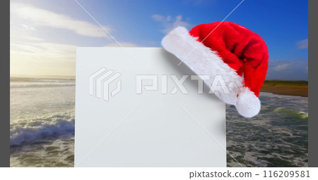 Digital composite of Santa hat with white card and sea Digital composite of Santa hat with white card and sea 116209581