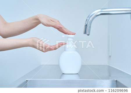A woman washing her hands with hand soap A woman washing her hands with hand soap 116209696