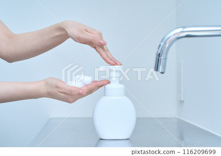 A woman washing her hands with hand soap A woman washing her hands with hand soap 116209699
