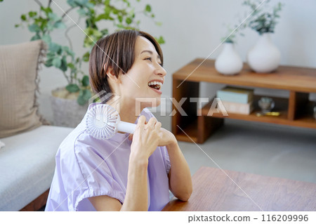 一位女士在客廳使用便攜式風扇 116209996