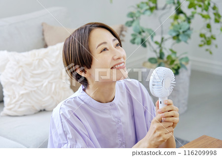 一位女士在客廳使用便攜式風扇 116209998