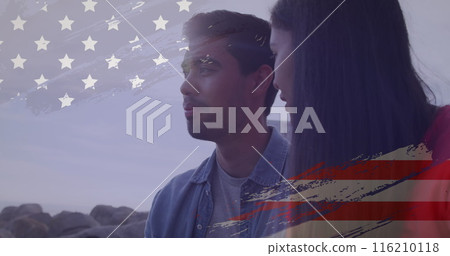 Image of usa flag effect against biracial couple talking to each other at the beach 116210118