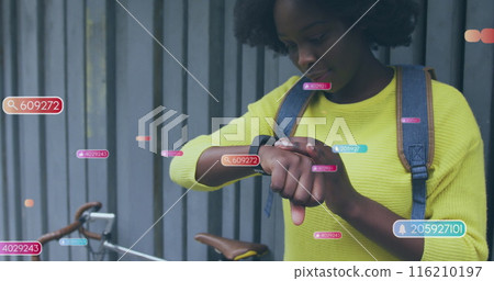Image of social media icons and data over african american woman using smartwatch Image of social media icons and data over african american woman using smartwatch 116210197