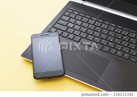 黃色背景中的筆記型電腦和智慧型手機 116211191
