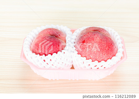 Two packed peaches on a table 116212089