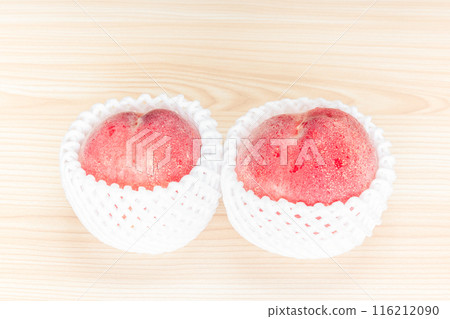 Two peaches on a table 116212090