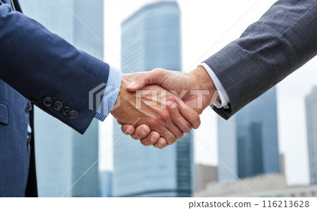 Business handshake agreement success corporate deal partnership professional men suit greeting negotiation city background urban skyline daytime outdoor meeting collaboration 116213628