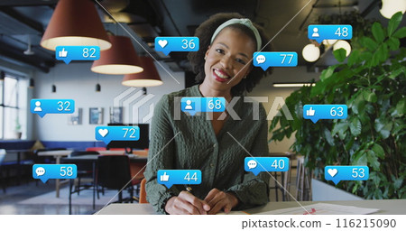 Image of social media icons over african american woman talking looking at the camera at office 116215090