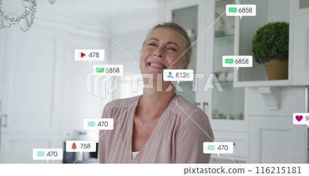 Image of social media icons over caucasian senior woman smiling at home Image of social media icons over caucasian senior woman smiling at home 116215181