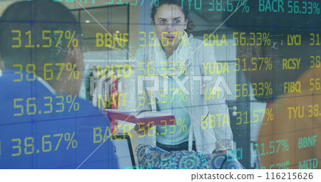 Image of trading board over diverse designers discussing design on laptop in office Image of trading board over diverse designers discussing design on laptop in office 116215626