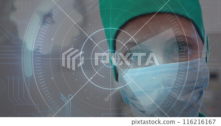 Image of round scanner against caucasian senior female surgeon wearing surgical mask at hospital Image of round scanner against caucasian senior female surgeon wearing surgical mask at hospital 116216167