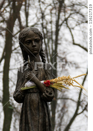 Sculpture of hungry young girl with ears of wheat in their hands. Kiev, Ukraine 116217319