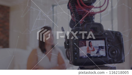 Image of network of connections over camera screen with female vlogger recording vlog at home 116218005