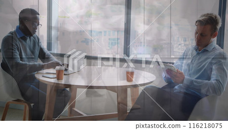Image of african american man working on laptop while caucasian man reading tablet Image of african american man working on laptop while caucasian man reading tablet 116218075