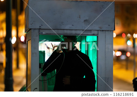 A man is talking on a phone at noir style in booth 116218691