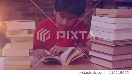 Image of light trails over biracial boy reading books 116219635