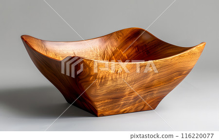 A square wooden bowl, crafted from a rich, warm-toned wood, sits on a gray background. A square wooden bowl, crafted from a rich, warm-toned wood, sits on a gray background. 116220077