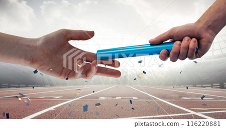 Confetti falling over close up of a hand passing a baton against sports field 116220881