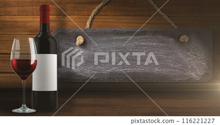 Image of lights over bottle and glass of red wine over wooden background with tag Image of lights over bottle and glass of red wine over wooden background with tag 116221227