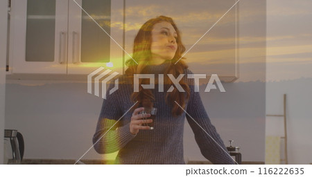 Image of sunset landscape over caucasian woman drinking coffee in kitchen Image of sunset landscape over caucasian woman drinking coffee in kitchen 116222635