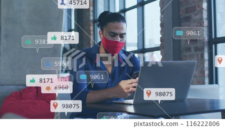 Image of social media icons and numbers over biracial businessman in face mask with laptop Image of social media icons and numbers over biracial businessman in face mask with laptop 116222806