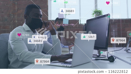 Image of icons and numbers over african american man in face mask using smartphone Image of icons and numbers over african american man in face mask using smartphone 116222812