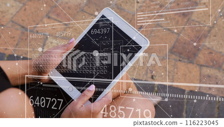 A businesswoman is using a digital tablet outside an office building 116223045