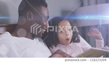 Image of light spots over happy african american father reading book with daughter Image of light spots over happy african american father reading book with daughter 116223204