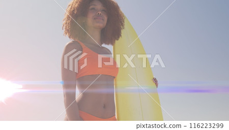 Image of lights over african american woman holding surfboard Image of lights over african american woman holding surfboard 116223299