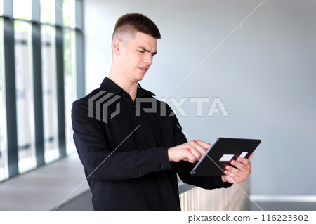 guy with broken hands holds a tablet in his hands after fight 116223302