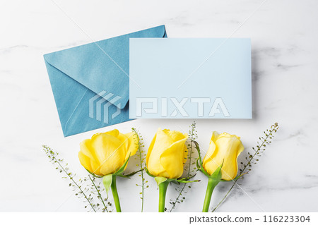 Blue card with envelope and yellow roses on white table background, father's day gift and card, top view 116223304