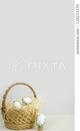 Handmade art. Thread embroidery on eggs. Easter in a wicker straw basket there are white eggs with a beautiful decoration of ribbons to embroider at home Handmade art. Thread embroidery on eggs. Easter in a wicker straw basket there are white eggs with a beautiful decoration of ribbons to embroider at home 116223370
