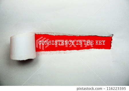 Consistency Is The Key message written on red paper with torn paper background 116223395