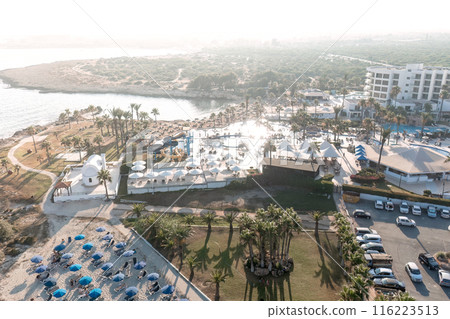 Aerial perspective of a seaside resort with pools and beaches during a tranquil sunset. Nissi beach, Ayia Napa, Cyprus 116223513