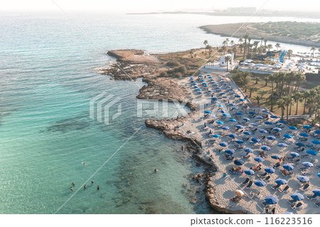 Coastal vacation spot with sun umbrellas and swimmers.Ayia Napa, Cyprus Coastal vacation spot with sun umbrellas and swimmers.Ayia Napa, Cyprus 116223516