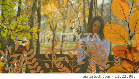 Young Caucasian man sitting on bench holding a coffee cup in park 116223995