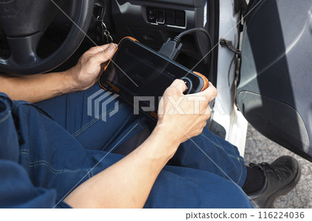 Auto mechanic using a car diagnostic device 116224036
