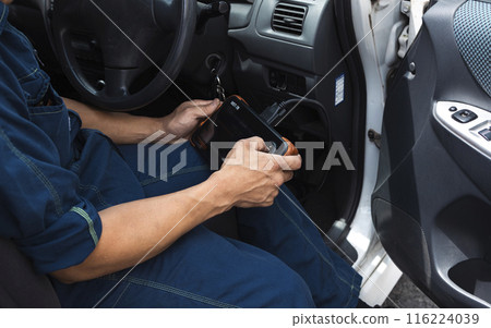 Auto mechanic using a car diagnostic device Auto mechanic using a car diagnostic device 116224039
