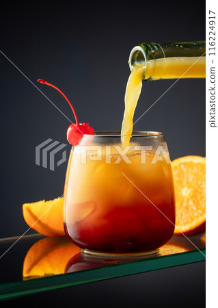 Tequila Sunrise alcoholic cocktail on a dark background. 116224917