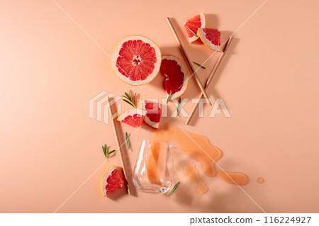 Grapefruit slices, rosemary, straws, and an empty glass. Grapefruit slices, rosemary, straws, and an empty glass. 116224927