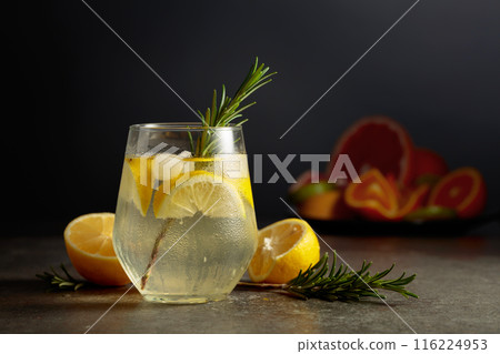 Cocktail gin tonic with ice, rosemary, and lemon on a stone table. Cocktail gin tonic with ice, rosemary, and lemon on a stone table. 116224953