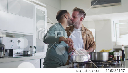 Image of light spots over diverse male couple cooking dinner in kitchen 116226157