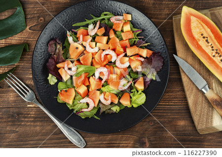 Seafood salad and papaya on a wooden table. Seafood salad and papaya on a wooden table. 116227390