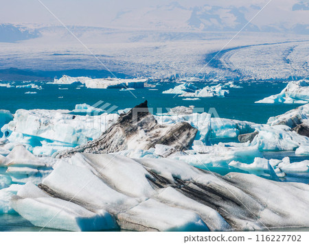 Aerial view of the big pieces of ice from glacier, ice islands, glacier and mountains, Jokulssrlon - Glacier Lagoon. A large glacial lake in southern part of Vatnajokull National Park, Iceland Aerial view of the big pieces of ice from glacier, ice islands, glacier and mountains, Jokulssrlon - Glacier Lagoon. A large glacial lake in southern part of Vatnajokull National Park, Iceland 116227702