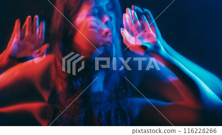 Split personality. Blur silhouette. Distracted delusional woman holding hands barrier neon red blue color dark double exposure out of focus. Split personality. Blur silhouette. Distracted delusional woman holding hands barrier neon red blue color dark double exposure out of focus. 116228266